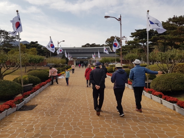 예산군 윤봉길의사기념관을 방문한 관람객이 국화 꽃길 사이를 지나가고 있다.